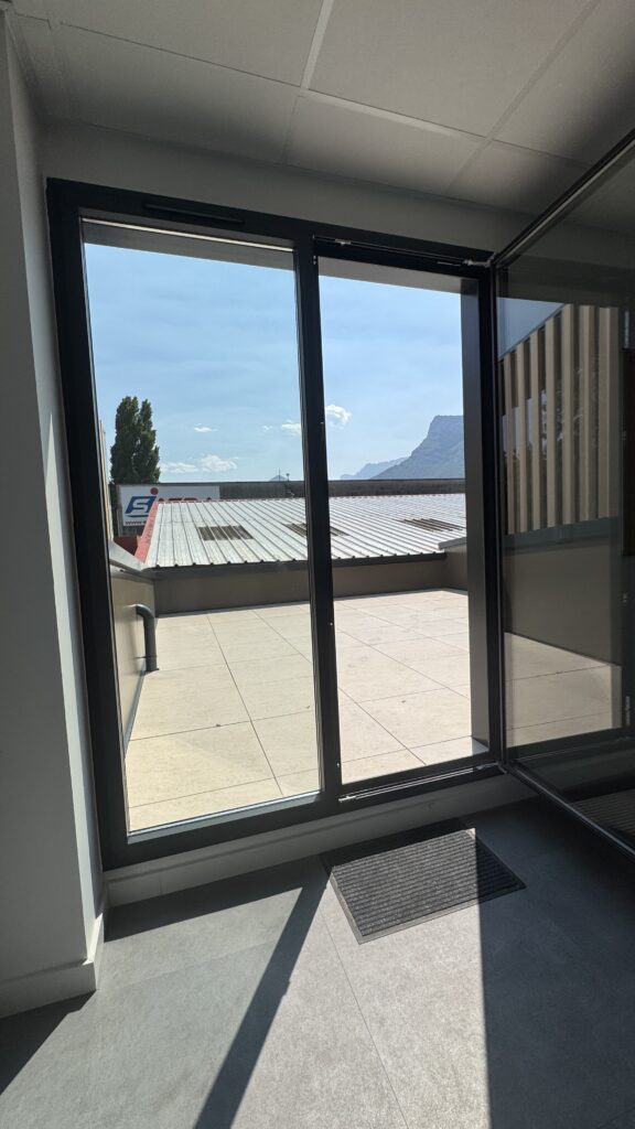 Baie vitrée d’angle ouvrant sur la terrasse, locaux MTI à Claix